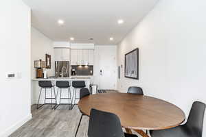 Dining room with sink and light wood-type flooring