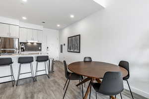 Dining space featuring sink and light wood-type flooring