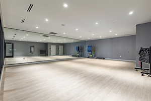 Workout room with light hardwood / wood-style floors