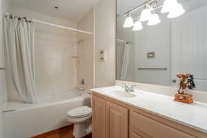 Full bathroom with shower / tub combo, vanity, tile patterned floors, and toilet