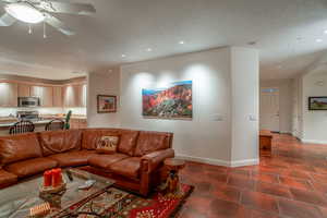 Tiled living room with sink and ceiling fan