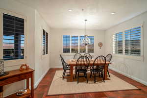 Dining space featuring a chandelier and dark tile patterned floors