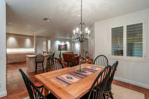 Dining room with tile patterned flooring and an inviting chandelier