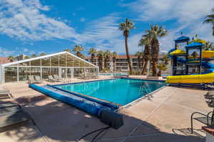 View of pool with a patio and a water slide