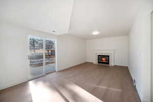 Unfurnished living room featuring a tile fireplace and light wood-type flooring