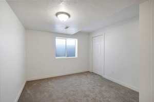 Carpeted spare room featuring a textured ceiling