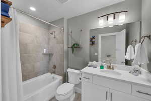 Full bathroom featuring shower / bathtub combination with curtain, vanity, and toilet