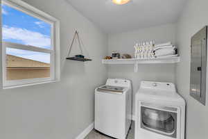 Washroom featuring washing machine and dryer and electric panel