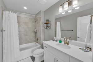 Full bathroom with vanity, toilet, and shower / bath combo with shower curtain