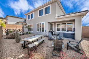 Rear view of property featuring a hot tub and a patio area