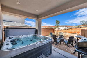 View of patio / terrace with area for grilling, a fire pit, and a hot tub