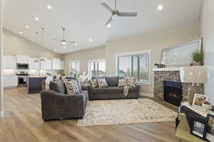 Living room featuring a fireplace, light hardwood / wood-style floors, and ceiling fan