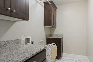 Laundry room with cabinets, hookup for a washing machine, and electric dryer hookup