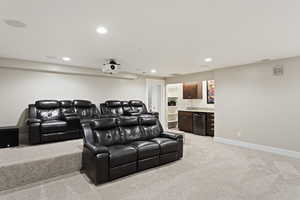 Cinema room featuring light carpet