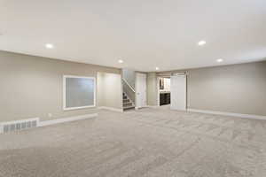 Basement featuring a barn door and light carpet