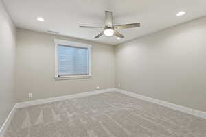 Carpeted spare room with ceiling fan