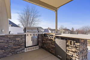 View of patio featuring exterior kitchen and sink