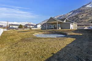 Rear view of property with a mountain view and a yard