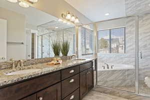 Bathroom featuring vanity, independent shower and bath, and a textured ceiling