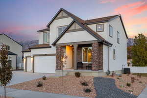 View of front of house with cooling unit, a garage, a mountain view, and covered porch