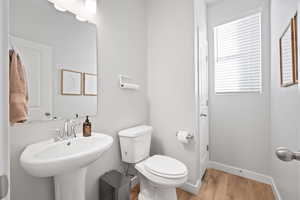 Bathroom with sink, hardwood / wood-style flooring, and toilet