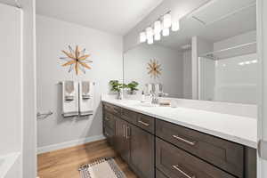 Bathroom with vanity, hardwood / wood-style floors, and a shower