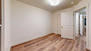 Unfurnished bedroom featuring lofted ceiling and light wood-type flooring