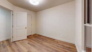 Unfurnished bedroom with light hardwood / wood-style flooring