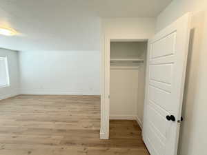 First floor living with coat closet, light wood finished floors, a closet