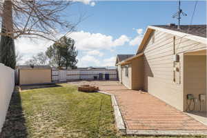 View of yard featuring a storage shed, a patio area, and a fire pit