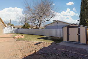 View of yard with a patio and a storage shed