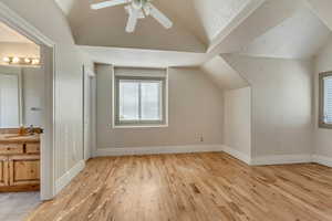 Bonus room featuring sink, vaulted ceiling, light hardwood / wood-style floors, and ceiling fan