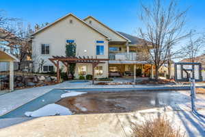 Snow covered property featuring a balcony and a pergola