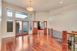 Doorway to outside with hardwood / wood-style floors, french doors, and a high ceiling