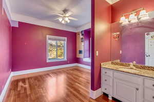 Bathroom with hardwood / wood-style flooring, vanity, and ceiling fan