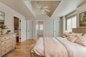 Bedroom featuring ceiling fan, connected bathroom, light hardwood / wood-style floors, and a textured ceiling