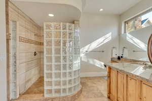 Bathroom featuring vanity and a tile shower