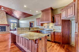 Kitchen featuring lofted ceiling, sink, a kitchen bar, double oven range, and kitchen peninsula