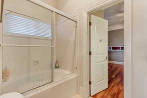 Bathroom featuring hardwood / wood-style flooring and enclosed tub / shower combo