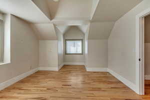 Additional living space with lofted ceiling and light wood-type flooring