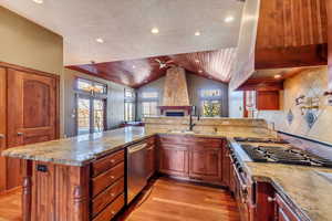 Kitchen featuring sink, vaulted ceiling, wooden ceiling, stainless steel dishwasher, and backsplash