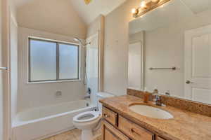 Full bathroom featuring tile patterned floors, toilet, vaulted ceiling, shower / bathing tub combination, and vanity