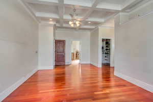 Unfurnished room with coffered ceiling, wood-type flooring, ornamental molding, ceiling fan, and beam ceiling