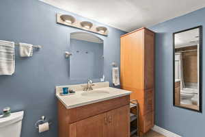 Bathroom featuring vanity, toilet, curtained shower, and tile patterned flooring