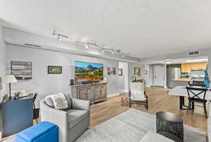 Living room with light hardwood / wood-style floors