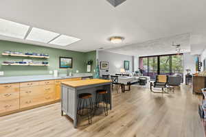 Kitchen with butcher block countertops, sink, a breakfast bar area, expansive windows, and light brown cabinets