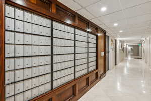 Main level hallway with, mailboxes, HOA Office, and building entry