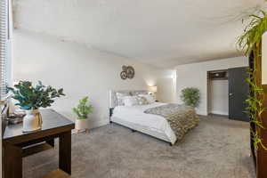 Bedroom with a textured ceiling and carpet