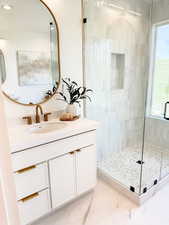 Bathroom with an enclosed shower, vanity, and a wealth of natural light