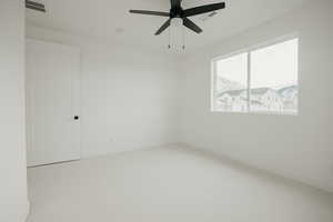 Room featuring ceiling fan, carpet flooring, and a mountain view